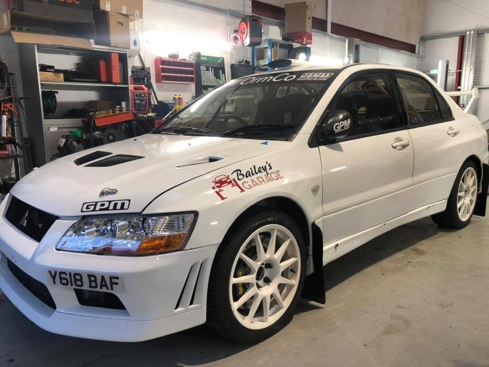 White Mitsubishi Evo with Bailey's Garage livery in the workshop